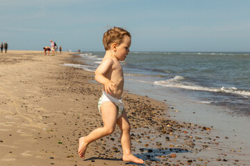 Fototapeta na wymiar Junge spielt ausgelassen am Strand, Grenen bei Skagen, Dänemark