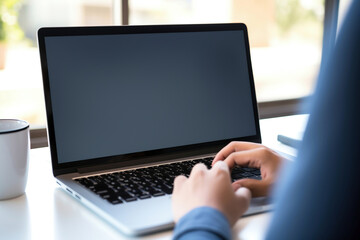 Photo of a person working on a laptop at a desk