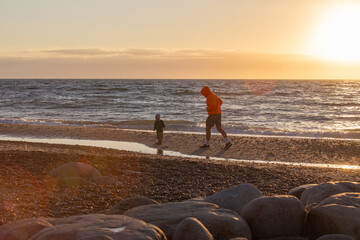 Familie mit Mann und Kind bei Sonnenuntergang über der Nordsee, Skagen, Dänemark