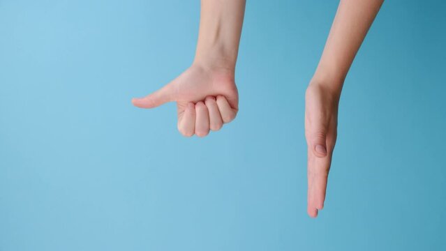 Vertical video of unrecognizable young woman opening and pointing on palm on copy space aside, makes thumb up, isolated over blue studio background wall with advertisement. Body language concept