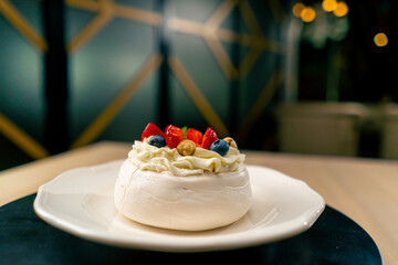 Obraz na płótnie Canvas A close-up of a fruit cake dessert lying on a white plate in an Italian restaurant 