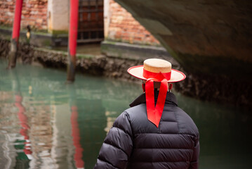 Gondolier in Venice with traditional hat - obrazy, fototapety, plakaty