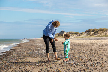 Frau mit Kind am Nordseestrand von Skagen, Dänemark