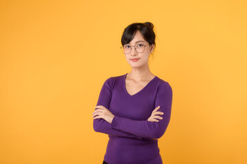 Obraz premium Lifestyle, people emotions and casual concept. Confident nice smiling young 30s asian woman cross arms chest confident, listening to coworkers, taking part conversation isolated on yellow background.