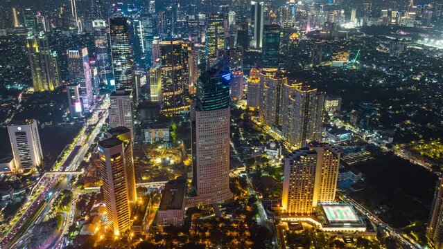 Night aerial view of skyscrapers and multi lane highway in large urban city center Cityscape of high rise buildings in Jakarta, Indonesia at night 
