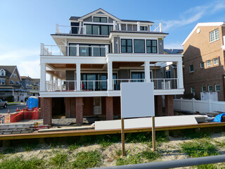 A modern new home that is elevated is seen being constructed