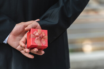 businessman carry red present in hands for romantic date at valentine. man in suit holding red...