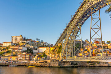 Scenic view of Porto in Portugal with Maria Pia bridge in warm winter sunset light 
