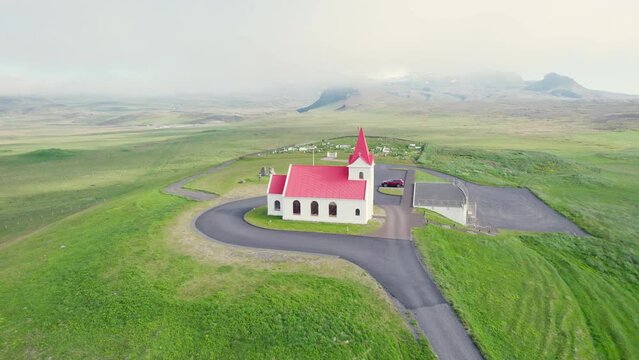 Beautiful holy Ingjaldsholl church on hill in foggy during summer at Snaefellsnes, Iceland