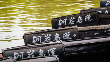 Docked by the lakeside are boats with a distinctive Hangzhou, China style, and the name written on them means 'Boats with Tassel Roofs