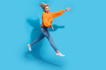 Fototapeta na wymiar Full size profile photo of energetic cheerful girl jump rush arms catch empty space isolated on blue color background