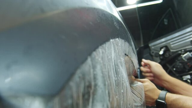 Process of applying a protective PPF film to a car. footage of applying a protective film on a car. 