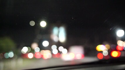 Blurred car lights bokeh in the evening city. Defocused headlights and street lighting at night. Moving bokeh circles of cars at night. Blurred city traffic background