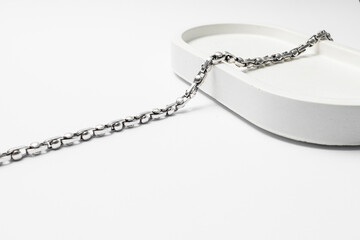 Silver chain on white plaster stand, subject macrophotography