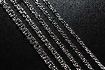 Silver chains lying on a black background, subject photography