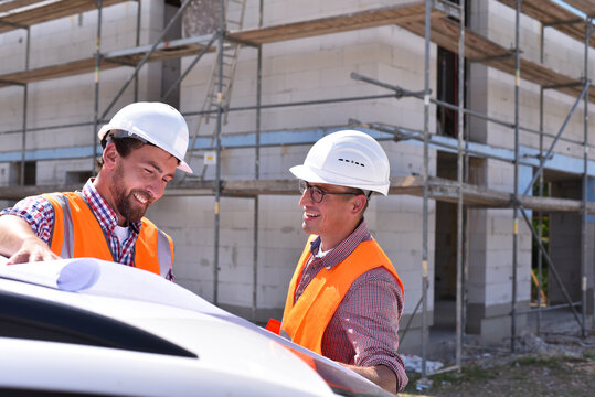 construction manager and architect on site during the construction of a house - planning and control on site - teamwork