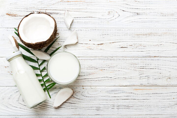 Fototapeta na wymiar coconut products on white wooden table background. Dairy free milk substitute drink, Flat lay healthy eating
