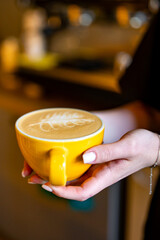 Woman barista hands holding cup of hot coffee latte cappuccino