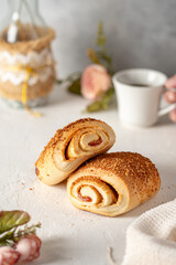 un pan con arequipe y queso rollo sobre otro pan en una mesa blanca con tematiac de una pasteleria 