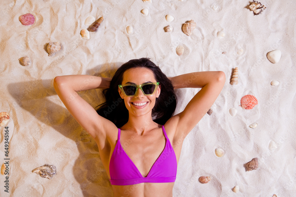 Sticker Top view photo of lady lying on sand hands over head sunbathing seashore isolated bright color background