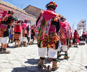 Pujillay festival in the town of Tarabuco, Bolivia. People are dancing wearing traditional clothes and wooden shoes called ojotas