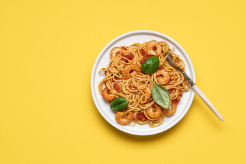 Shrimp marinara sauce pasta in plate on yellow background with copy space. Seafood spaghetti, Mediterranean cuisine