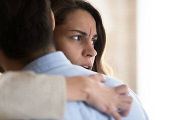 Close up frustrated thoughtful woman hugging man, thinking about relationship problems, pondering...