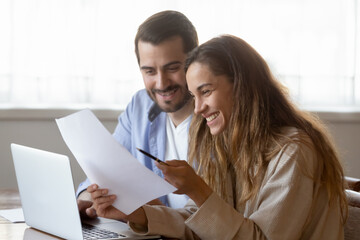 Happy young woman reading letter, loving couple excited by good news, taxes refund or mortgage loan...