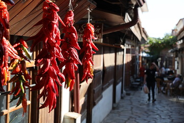 View close-up on garlands of dried red peppers hung on the counter of street spice shop