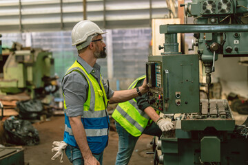 Senior hispanic engineer male expert worker work operate metal lathe milling machine in heavy...