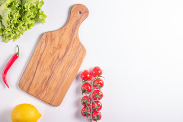 Wooden Cutting Board with Fresh Herbs and Raw Vegetables on Rustic Wood Table. Top view. Cooking...