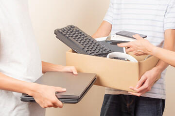 Volunteer collecting used technology gadgets to charity. Donation box with old laptop computers, phones, tablets, cords. E-waste, electronic waste for reuse, repair, recycle