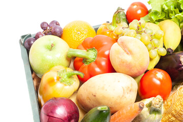 Fresh ripe vegetables and fruits in crate isolated on white background.