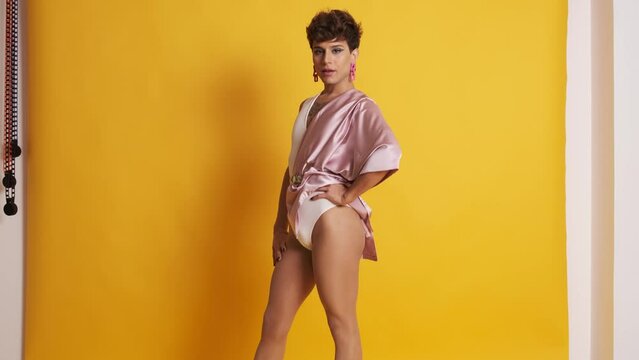 Transgender man with sensual fashion clothes posing in a photographic studio
