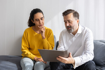 Senior professional business agent or financial lawyer tax advisor talking with indian woman about insurance contract document