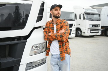 Portrait of young bearded trucker standing by his truck vehicle. Transportation service. Truck...