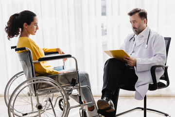 Psychiatrist doctor collect data talk with patient on wheelchair for mental care health problems check followup in hospital clinic - obrazy, fototapety, plakaty