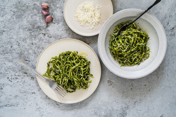 Plate of linguine pasta with greens and Parmesan cheese, healthy vegetarian meal