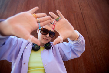 Waist up portrait of tough young girl wearing funky colorful outfit outdoors and looking at camera