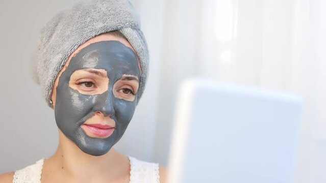 Woman with a cleansing face mask based on clay and activated carbon.