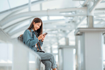 Happy tourist young asian woman with camera using social media on mobile phone on sky walk in a urban city. copy space.