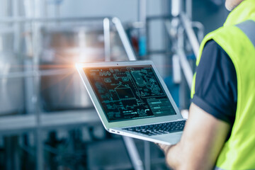 Engineer with laptop high technology software for industrial factory automation operate control service machine working monitor.