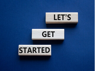 Lets get started symbol. Concept words Lets get started on wooden blocks. Beautiful deep blue...