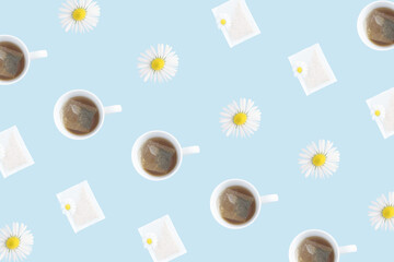 Top view pattern made out of a cup of tea, chamomile flower and a tea bag on the pastel blue background. Flat lay. Creative health and herbal concept.