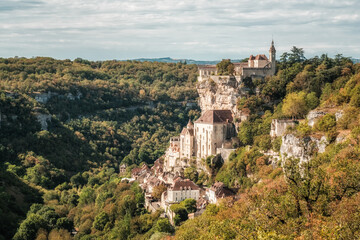 Perched on a cliff above a tributary of the Dordogne river, Rocamadour, a commune in the Lot region of France, dates back to the middle ages. It has been a centre of pilgrimage since the 15th century  - obrazy, fototapety, plakaty