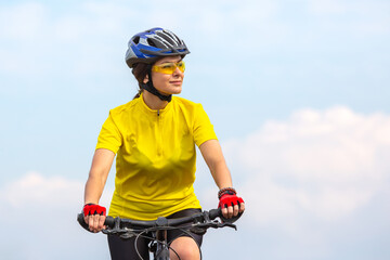 Beautiful woman cyclist in yellow clothes on the bike. sports, hobbies and entertainment for health - obrazy, fototapety, plakaty