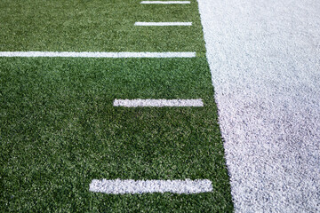 football field turf sideline. White dashes and out of bounds line