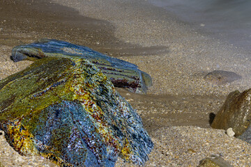 Colourful night long exposure of waves crashing against a rock on Patong Beach Phuket Thailand 
