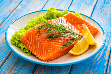 Fresh raw salmon steak with salt and fresh vegetables on wooden background
