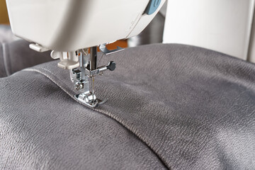 Modern sewing machine with gray velours fabric. Sewing process clothes, curtains upholstery....